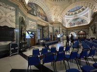 View of an empty stage in an large room with ornate carvings and pictures upon the walls.